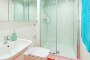 Bright bathroom with a shower enclosure, a wall-mounted basin and a wall-hung toilet.
