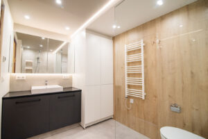 Walk-in shower with a rain head, beige stone-effect tiles, wall niches and a wall-hung toilet.