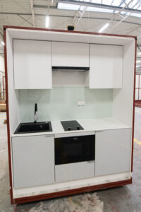Domczar prefabricated kitchen module with cabinets, a sink, an induction hob and an oven.
