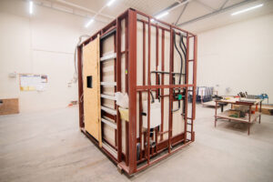 Prefabricated bathroom pod with an OSB door and plumbing on the frame.